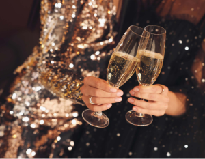 imagem uma pessoas segurando duas taças de champanhe em ano novo