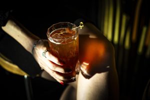 imagem mostra pessoa segurando um copo de drink